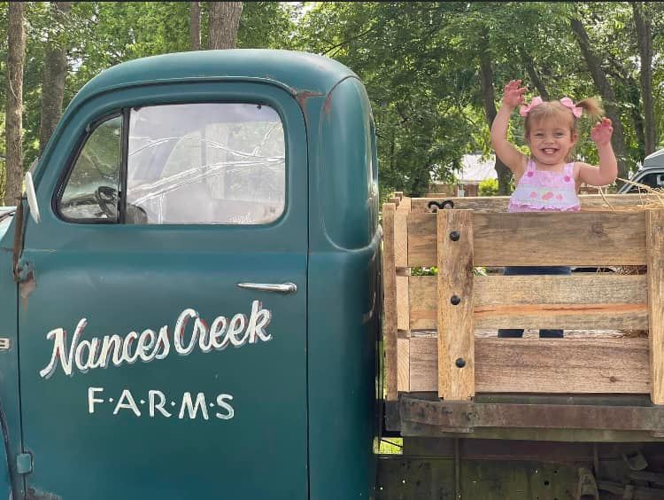 Smiling child on the Nances Creek Farms truck